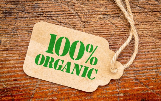 Wooden background with a tag that says "100% organic"